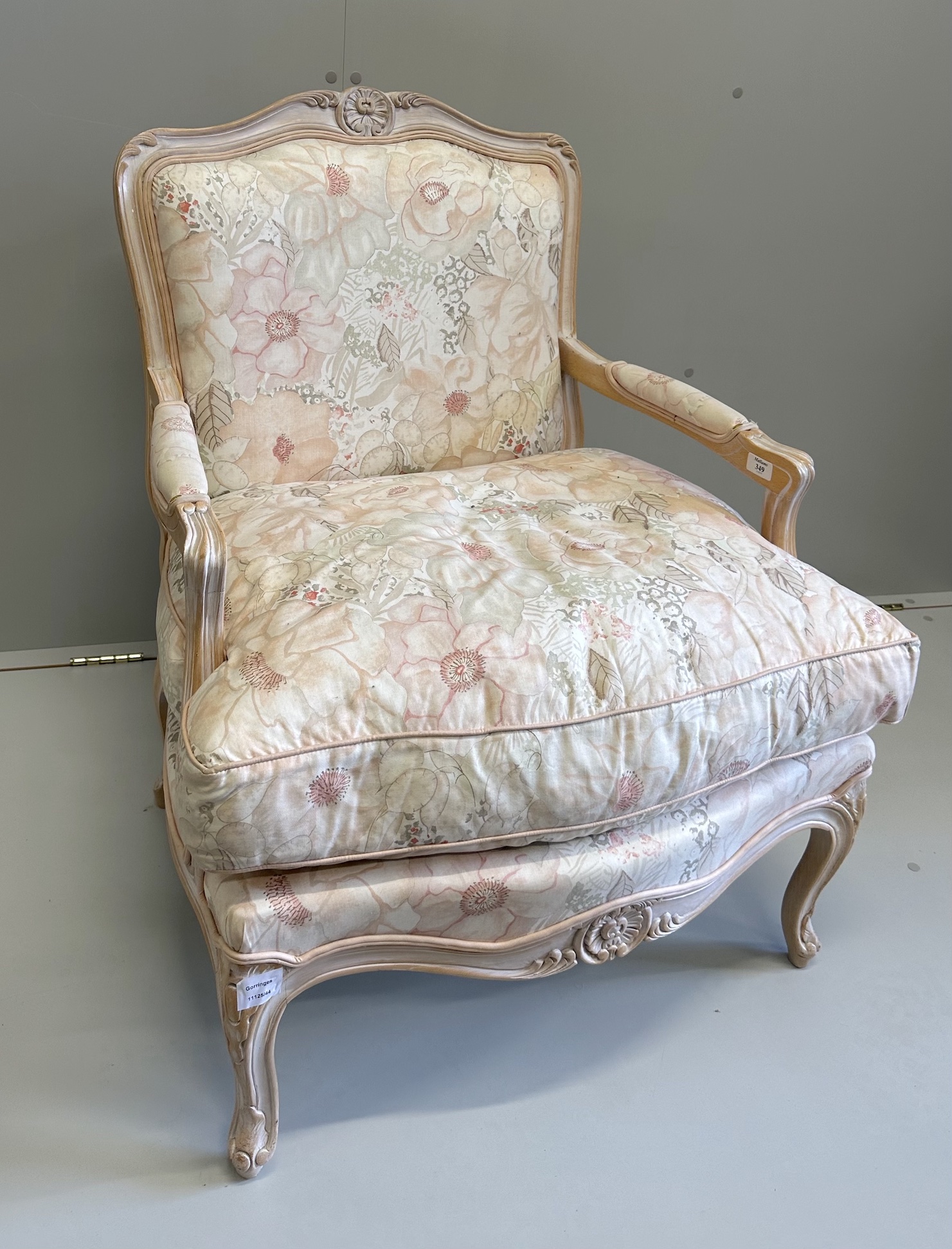 A Louis XV style bleached framed fauteuil, with floral upholstery and feather filled cushion seat, width 70cm, depth 60cm, height 89cm